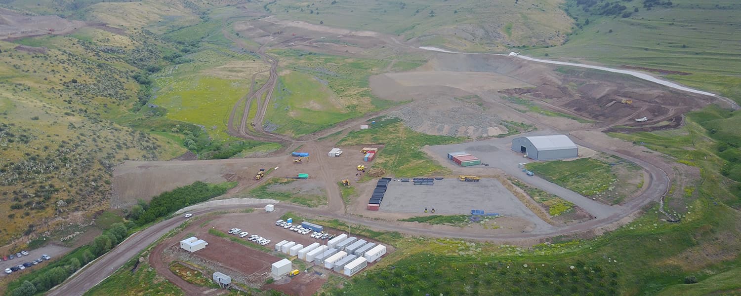 Aerial view of early construction at the Amulsar gold project in Armenia, showing the site camp, laydown yard, haul roads and earthworks on green hillsides