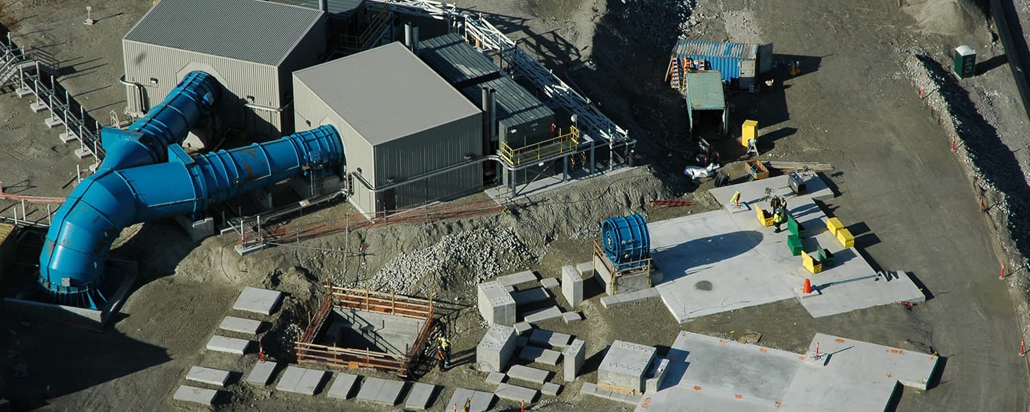 Aerial view of surface facilities under construction for the Diavik underground project, with large blue air ducts, equipment buildings and concrete foundations